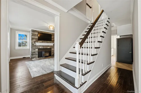 a view of a livingroom with wooden floor and stairs