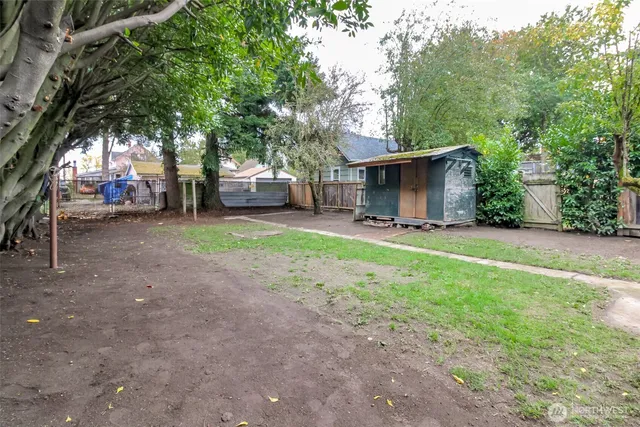 a view of a backyard with table and chairs and a large tree