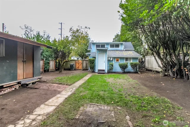 a view of a house with backyard and a tree