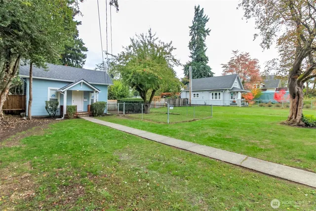 a front view of a house with a yard and trees