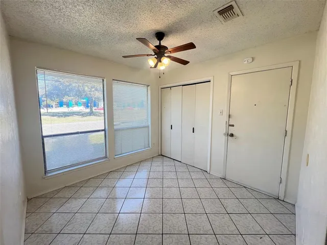 a view of an empty room and window chandelier fan