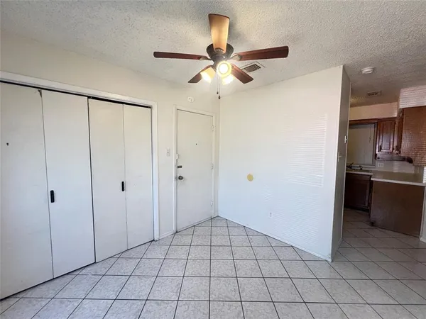 a view of an empty room and kitchen view
