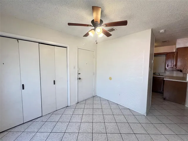 a view of an empty room and kitchen view