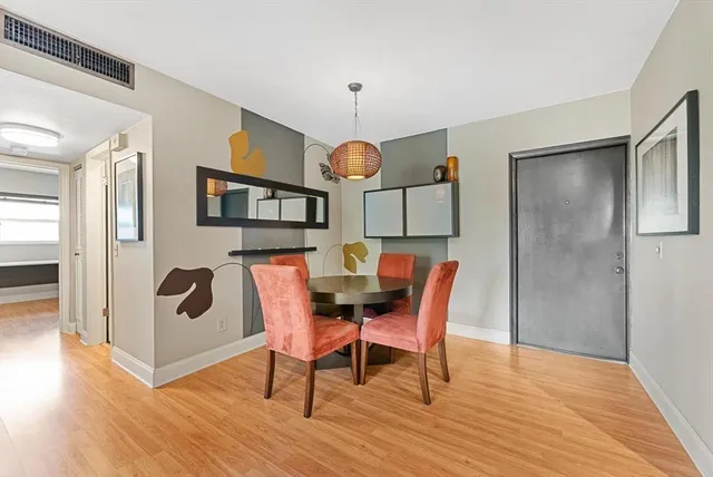 a dining room with furniture a mirror and wooden floor