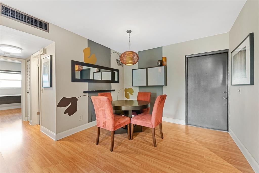 2451 Southwest 82nd Avenue, Unit 310 Davie, FL 33324 - Photo 9 of 21 a dining room with furniture a mirror and wooden floor