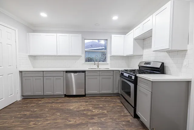 a kitchen with stainless steel appliances granite countertop a stove a sink and a microwave