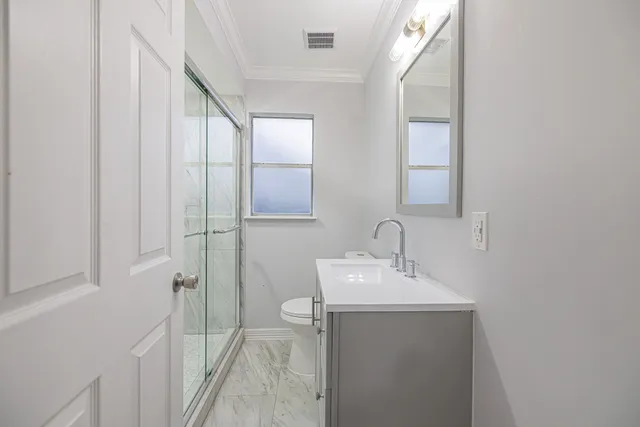 a bathroom with a sink a toilet and shower