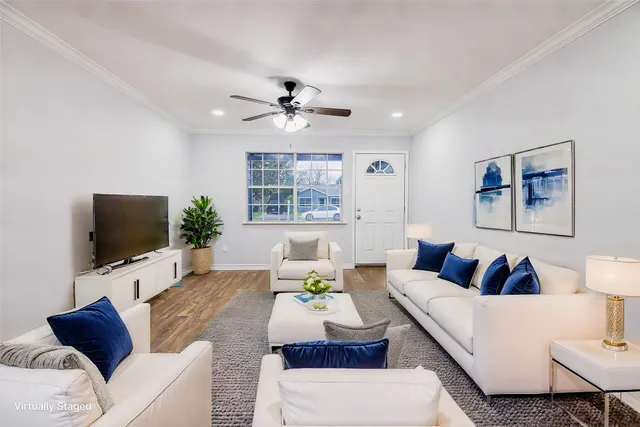 a living room with furniture a ceiling fan and a flat screen tv