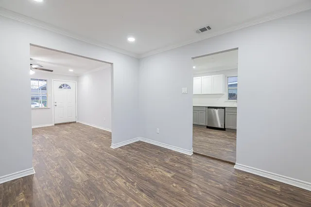 a view of empty room with wooden floor