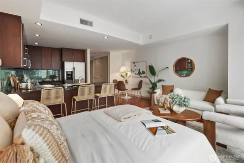 a living room with furniture kitchen view and large windows