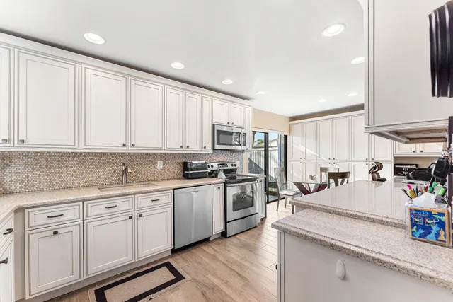 a kitchen with white cabinets and white appliances