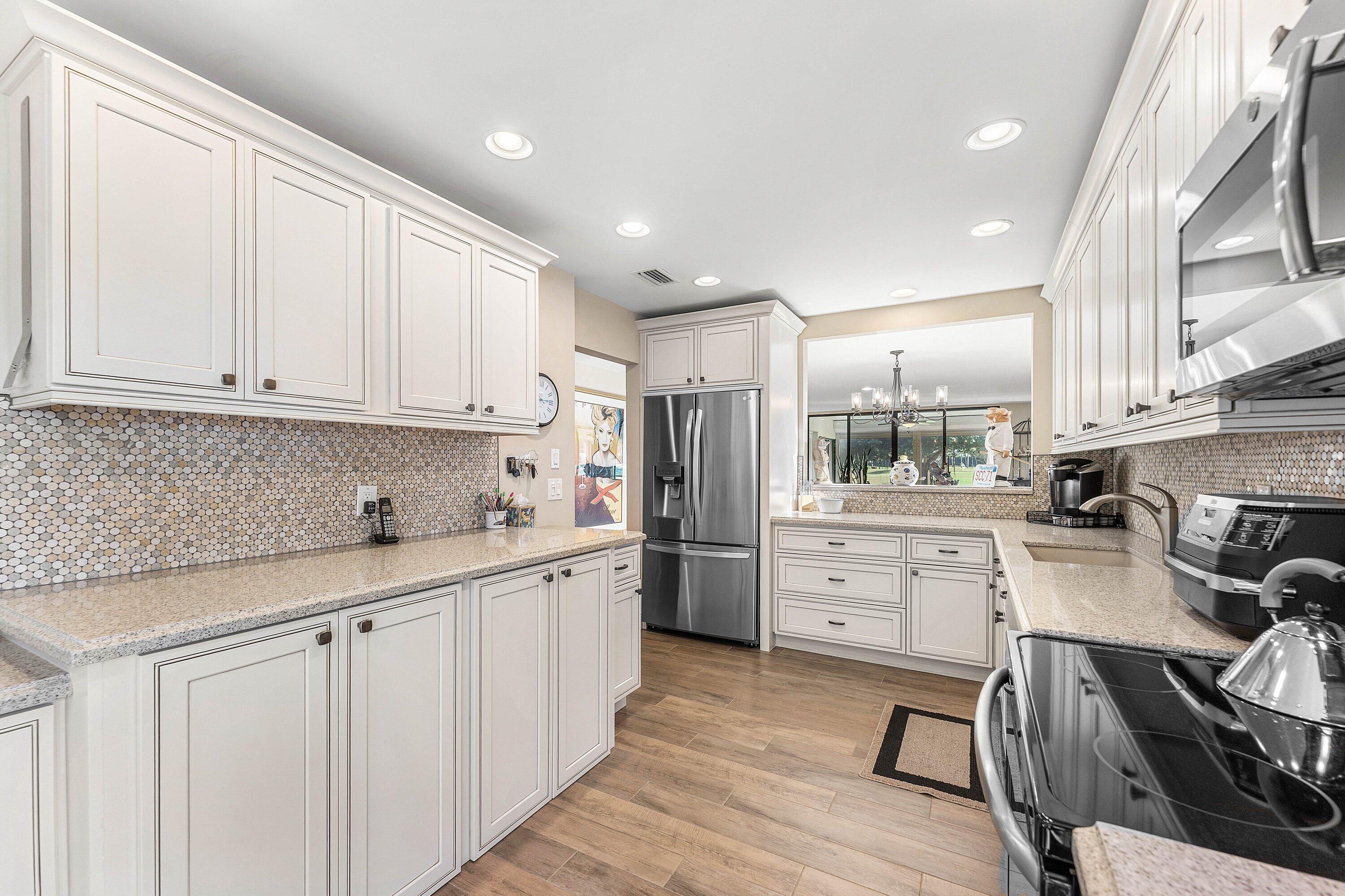 67 Eastgate Drive, Unit C Boynton Beach, FL 33436 - Photo 20 of 62 a kitchen with white cabinets and white appliances
