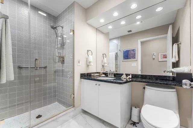 a bathroom with a granite countertop sink mirror and toilet