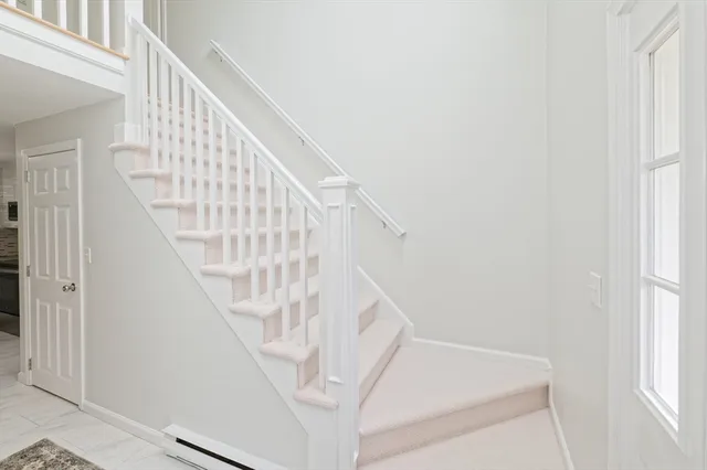 a view of staircase with railing and white walls