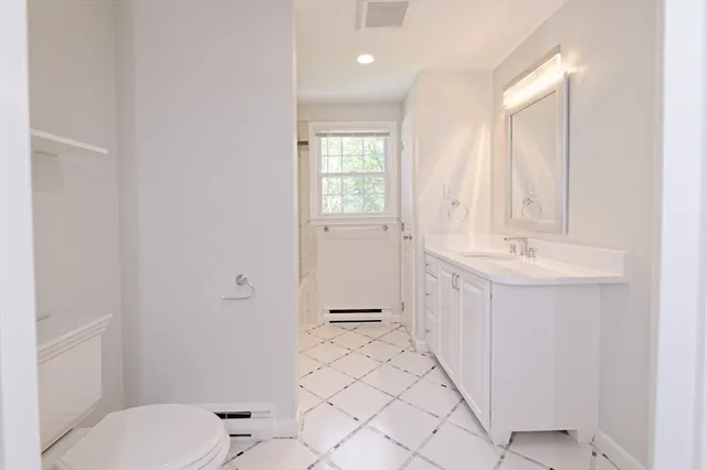 a bathroom with a sink a toilet and mirror
