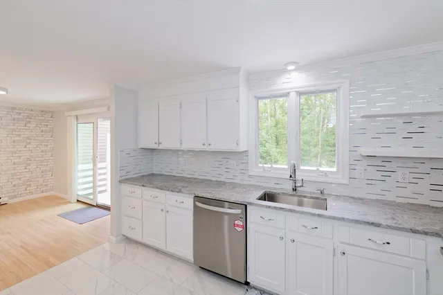 a kitchen with granite countertop white cabinets and a sink