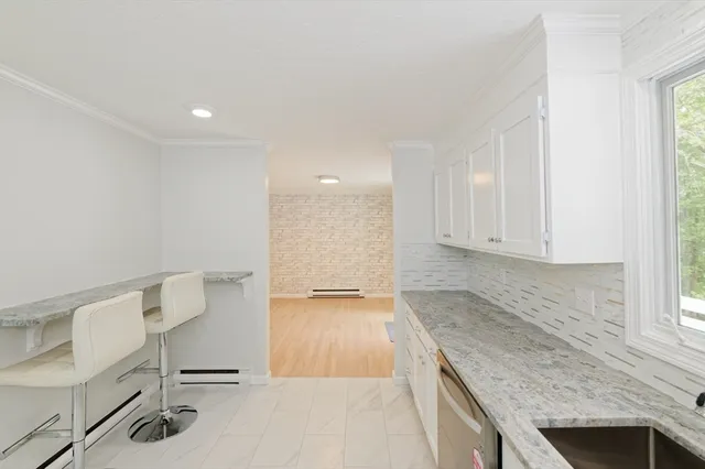 a view of kitchen with granite countertop cabinets and sink