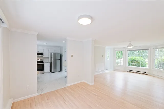 a view of a kitchen with wooden floor and a window