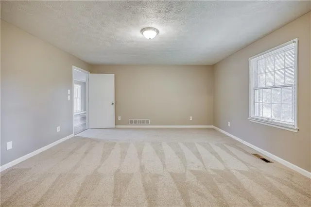 a view of hallway with closet and wooden floor