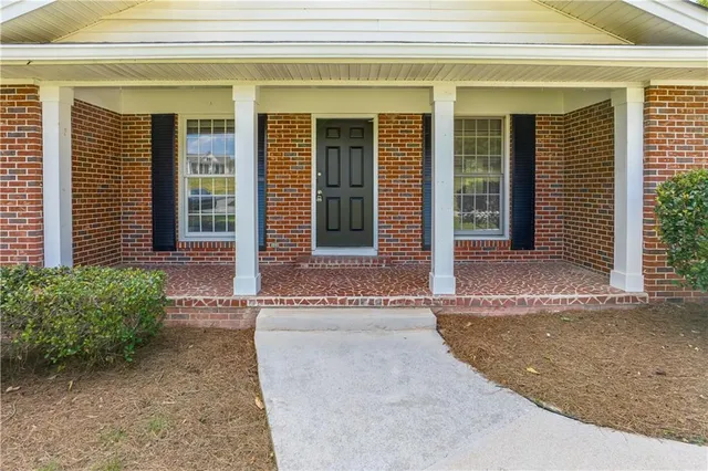 front view of a brick house with a large window
