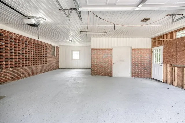a backyard of a house with large trees and plants