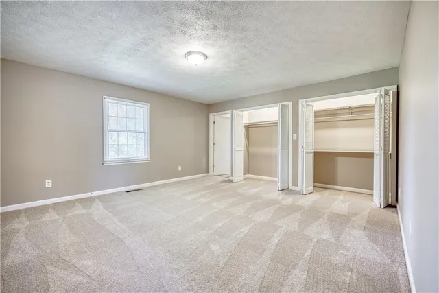 an empty room with windows and closet