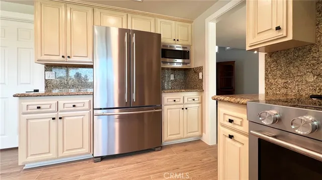 a kitchen with stainless steel appliances a refrigerator stove and cabinets