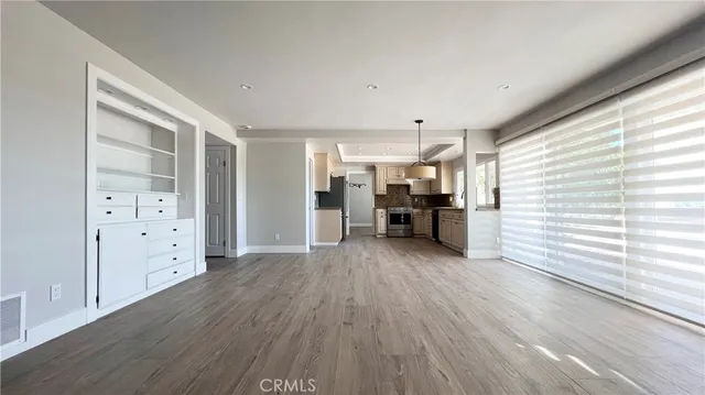 a view of a kitchen with furniture and wooden floor