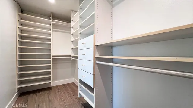 a view of walk in closet with empty racks