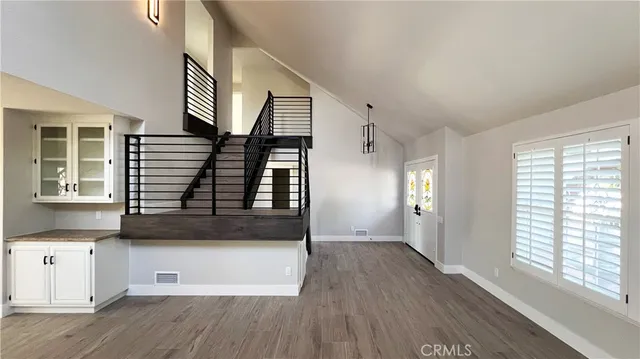 an entryway with wooden floor door and windows