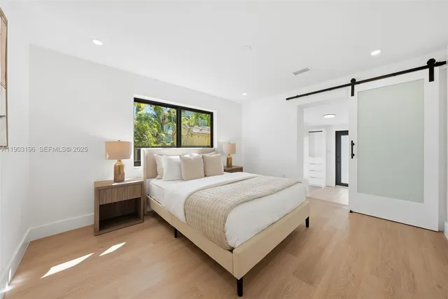 a bedroom with a bed and a painting on the wall