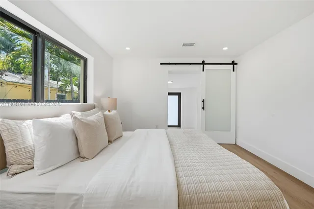 a spacious bedroom with a bed and a lamp