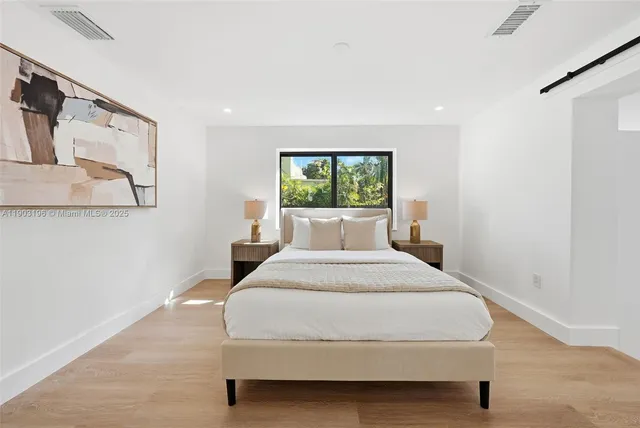 a bedroom with a large window and a bed