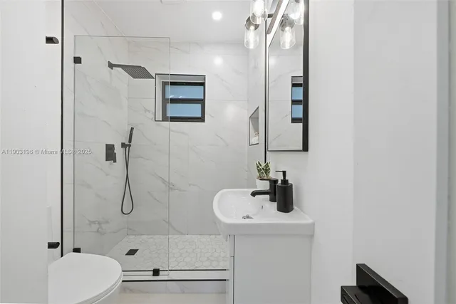 a bathroom with a sink toilet a mirror and shower