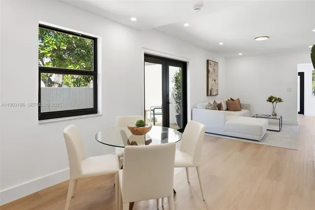 a view of a white house with a big yard and potted plants