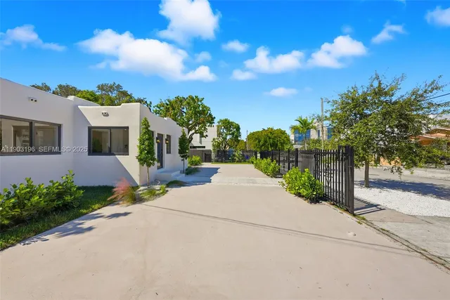 a front view of a house with a yard and potted plants