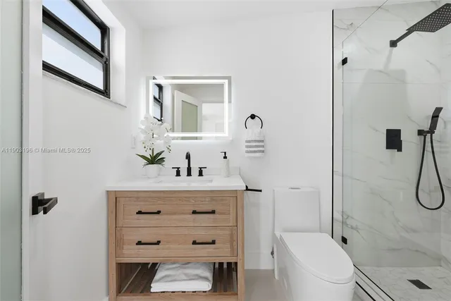 a bathroom with a sink a toilet and shower