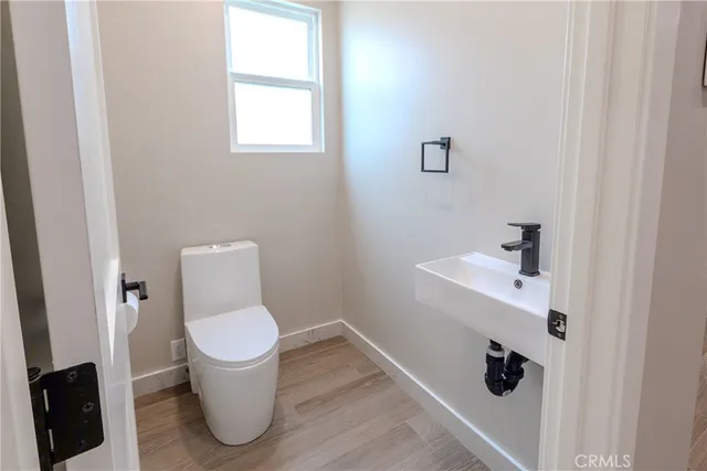 a view of kitchen with kitchen island wooden floor center island and stainless steel appliances