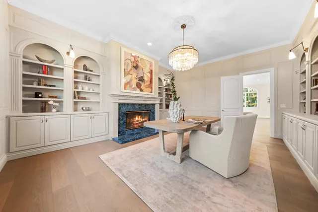 a dining room with wooden floor a chandelier a wooden table and chairs