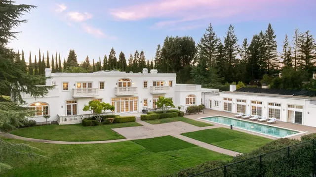 a living room with furniture a fireplace and a chandelier