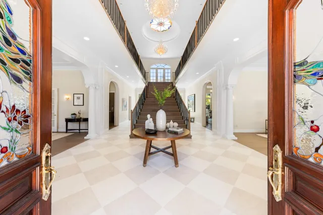 a living room with furniture a chandelier and a large window