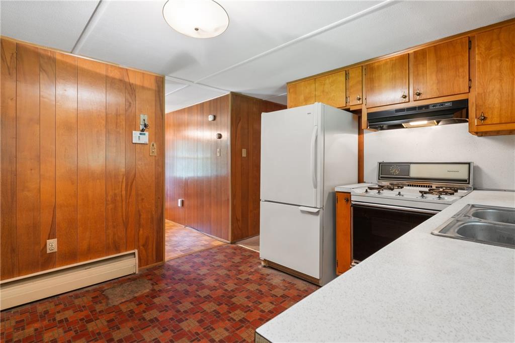 57 North Hope Mill Road Mercer, PA 16137 - Photo 14 of 49 a kitchen with wooden cabinets a sink a stove and a refrigerator