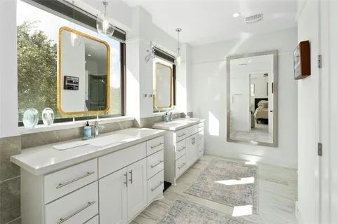 a spacious bathroom with double sink and a mirror