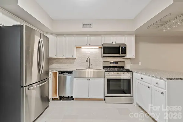 a kitchen with cabinets stainless steel appliances and a counter space
