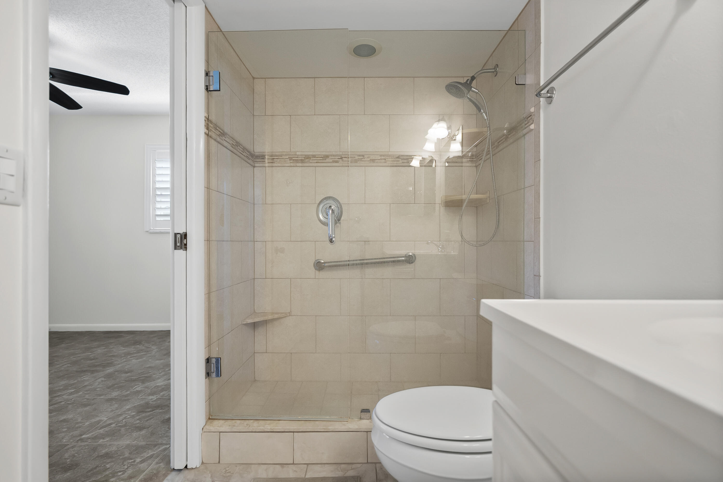 717 Highway 1, Unit 305 Jupiter, FL 33477 - Photo 12 of 51 a bathroom with a shower a toilet and sink