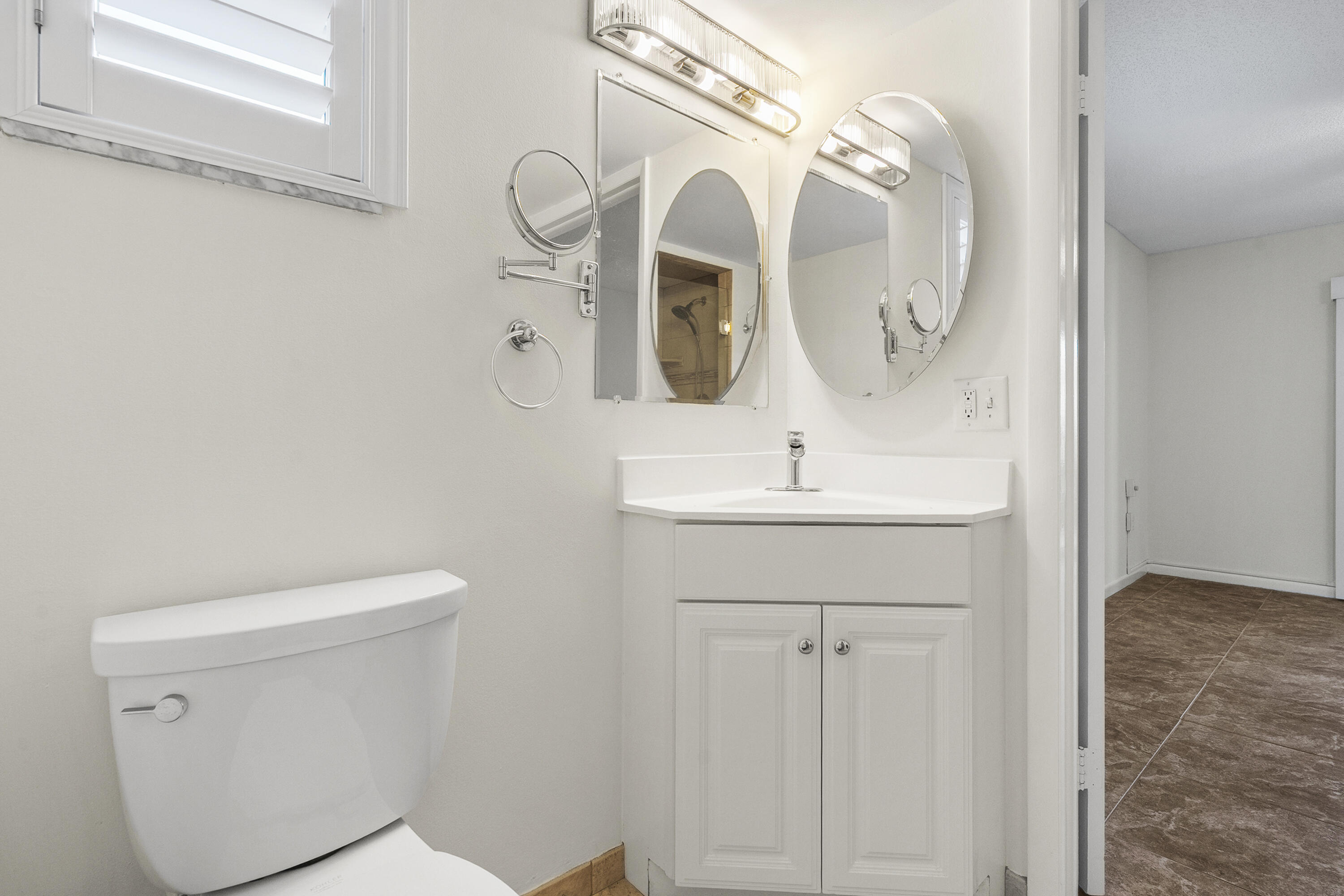 717 Highway 1, Unit 305 Jupiter, FL 33477 - Photo 14 of 51 a bathroom with a sink a toilet and mirror