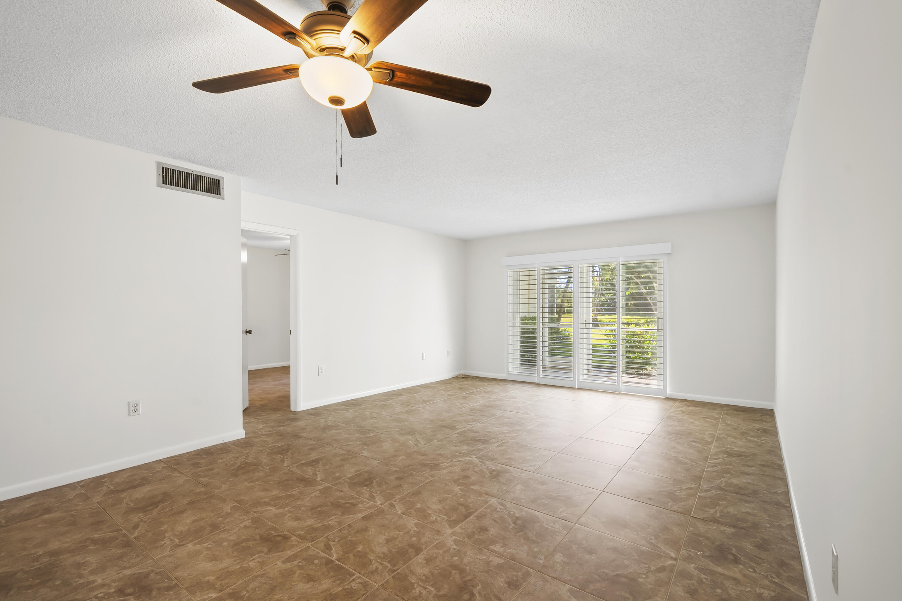 717 Highway 1, Unit 305 Jupiter, FL 33477 - Photo 20 of 51 a view of an empty room with chandelier fan and a window