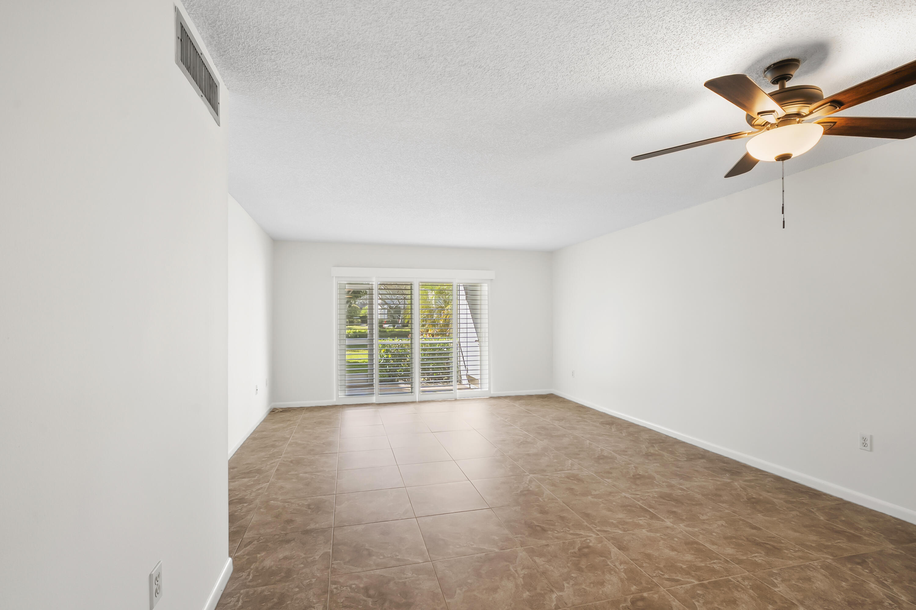 717 Highway 1, Unit 305 Jupiter, FL 33477 - Photo 21 of 51 an empty room with a ceiling fan and windows