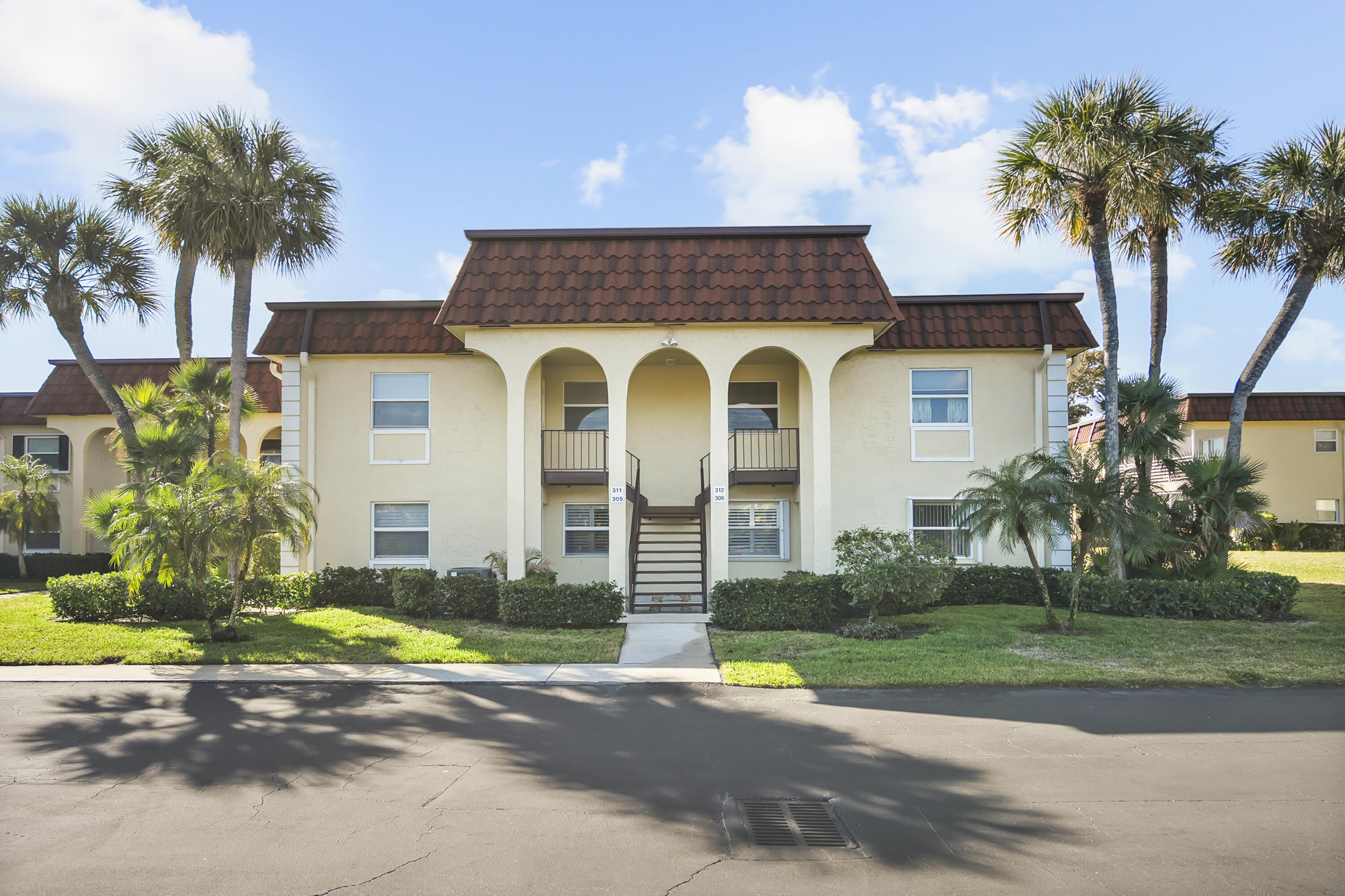 717 Highway 1, Unit 305 Jupiter, FL 33477 - Photo 51 of 51 a front view of a house with a garden and palm trees
