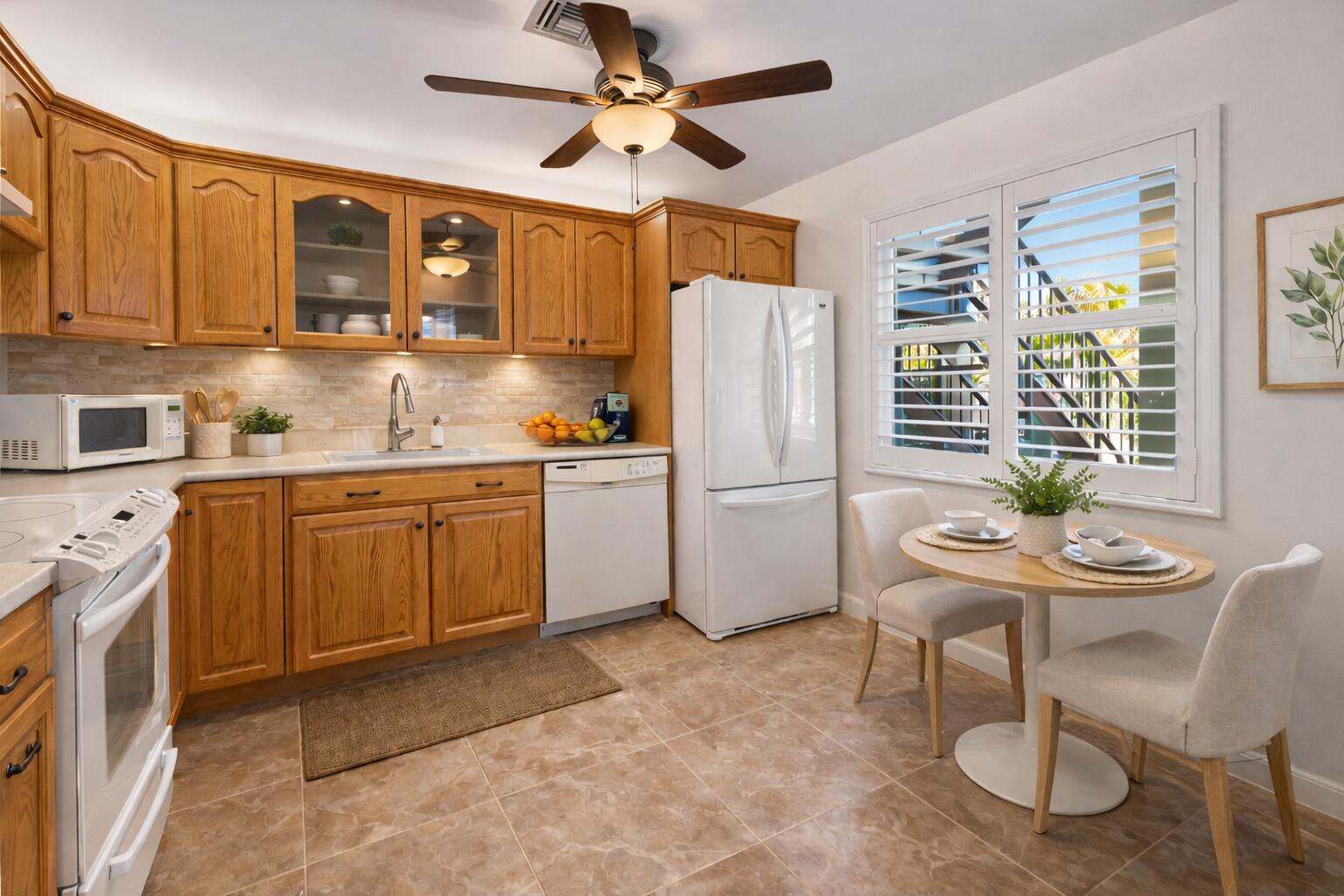 717 Highway 1, Unit 305 Jupiter, FL 33477 - Photo 7 of 51 a kitchen with a sink chairs and wooden cabinets